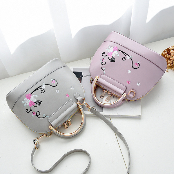 Modern női táska hímzéssel és fém elemmel