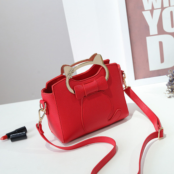 Stílusos kézitáska szalaggal és fém elemmel