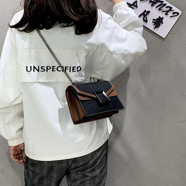 Korszerű női táska fém elemmel, hosszú füllel