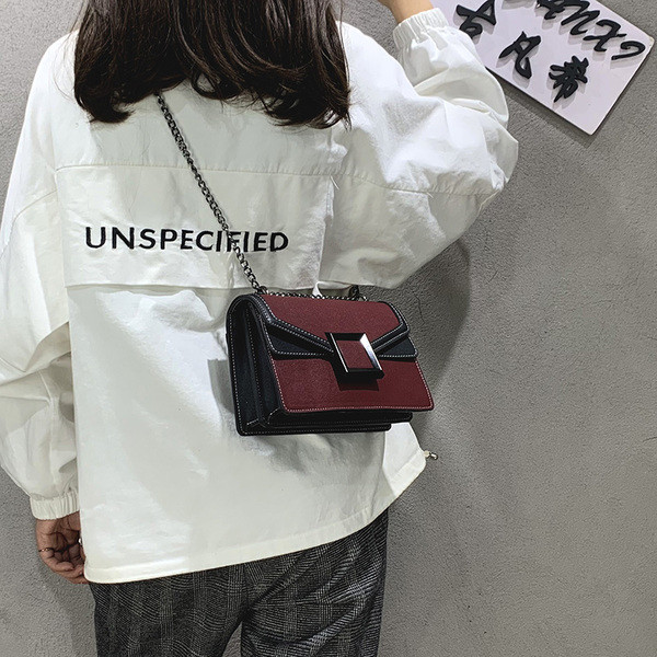 Korszerű női táska fém elemmel, hosszú füllel