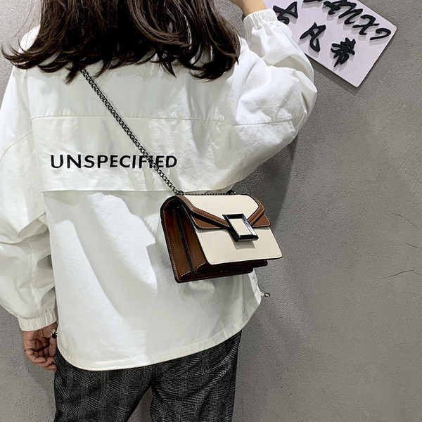 Korszerű női táska fém elemmel, hosszú füllel