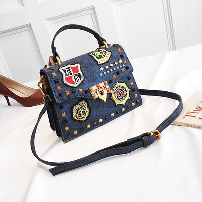 Γυναικεία  τσάντα με έμβλημα και μεταλλική διακόσμηση σε διάφορα χρώματα