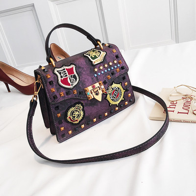 Γυναικεία  τσάντα με έμβλημα και μεταλλική διακόσμηση σε διάφορα χρώματα