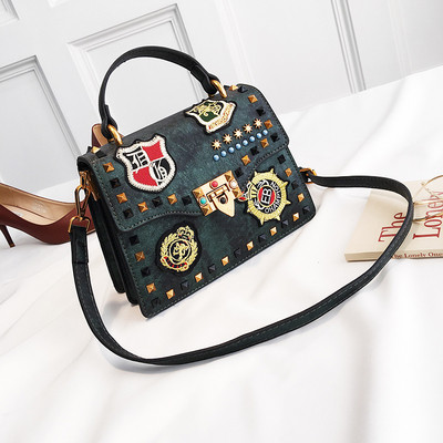 Γυναικεία  τσάντα με έμβλημα και μεταλλική διακόσμηση σε διάφορα χρώματα