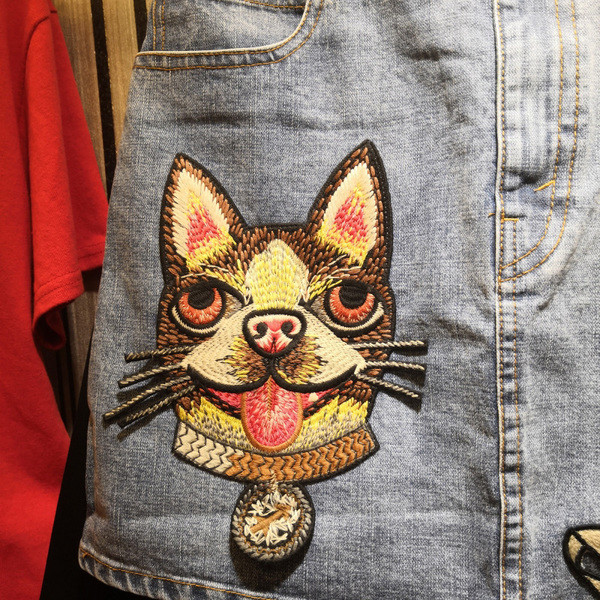 Modern női farmerszoknya színes emblémával, világos színben