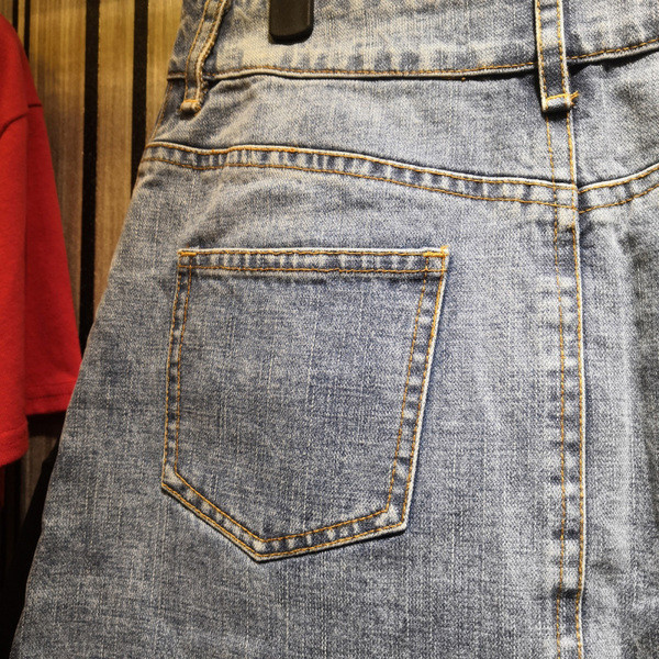 Modern női farmerszoknya színes emblémával, világos színben