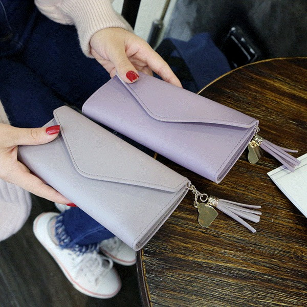 Γυναικείο μοντέρνο πορτοφόλι σε διάφορα χρώματα με φούντα και μεταλλική διακόσμηση