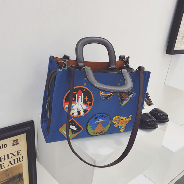 Geanta de dama moderna cu manere scurte si lungi si embleme colorate in doua culori