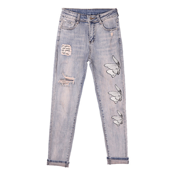 Modern női farmer szakadt motívummal és emblémával