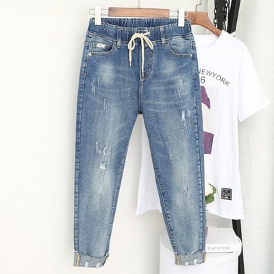 Casual women`s jeans with a high waist and a torn motif