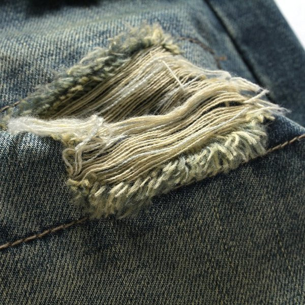 Modern férfi rövid farmernadrág kék színben, szakadt motívumokkal