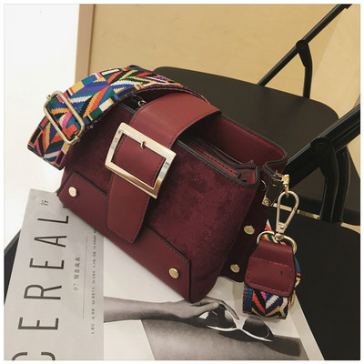 Stílusos kézitáska fém elemekkel és színes fogantyúval