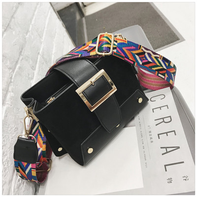 Stílusos kézitáska fém elemekkel és színes fogantyúval