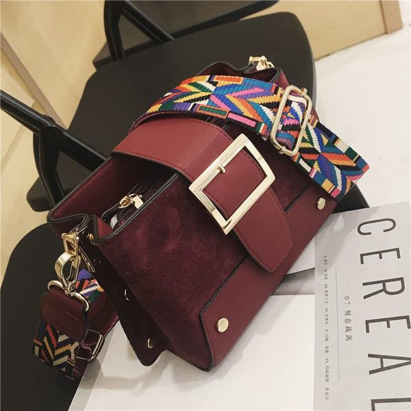 Stílusos kézitáska fém elemekkel és színes fogantyúval