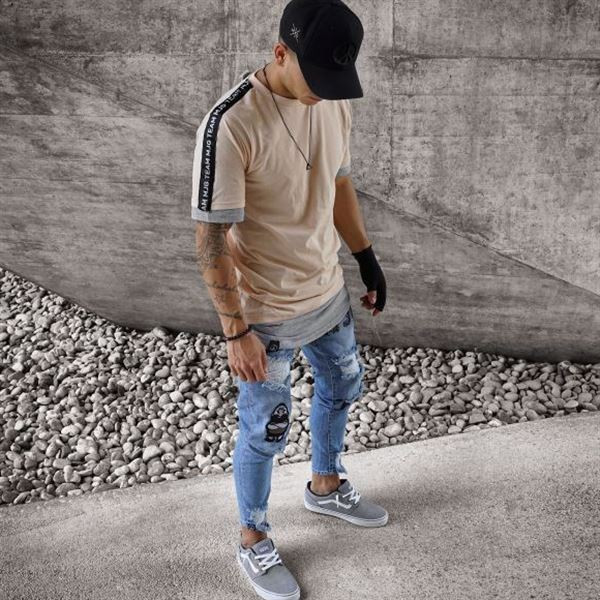 Modern férfi farmer szakadt motívumokkal és kék-fehér emblémákkal