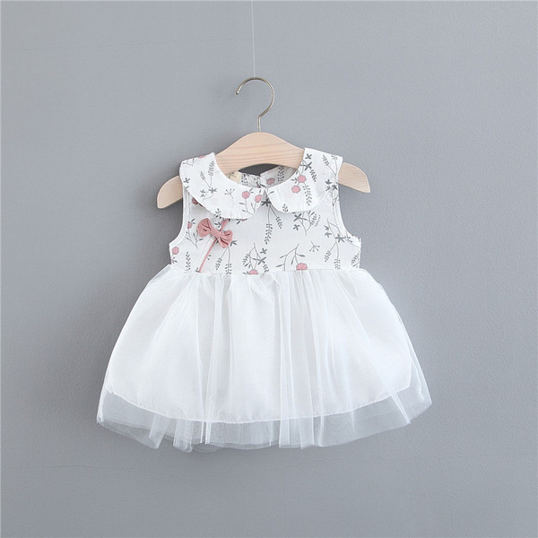 Modern, fehér színű gyerekruha szalaggal és tüllel