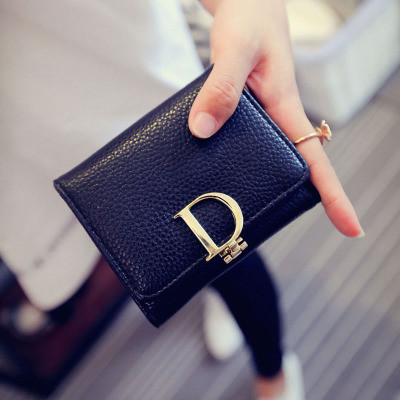 Κομψό γυναικείο πορτοφόλι με μεταλλικό στοιχείο σε μαύρο και χρυσό χρώμα