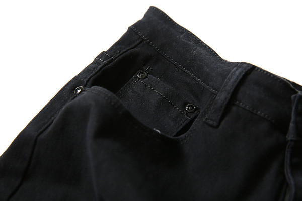 Modern férfi farmer fehér és fekete színben, szakadt motívumokkal