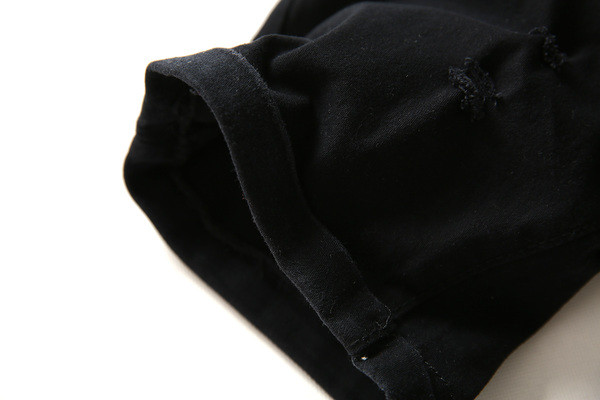 Modern férfi farmer fehér és fekete színben, szakadt motívumokkal