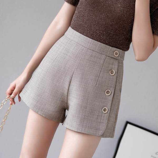 Női nadrág zsebekkel és dekorációs gombokkal