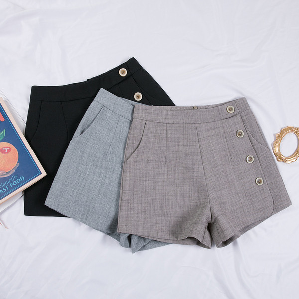 Női nadrág zsebekkel és dekorációs gombokkal