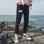 Modern férfi farmer fekete színben, szakadt motívumokkal és applikációkkal