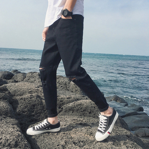 Modern férfi farmer fekete színben, szakadt motívumokkal és applikációkkal