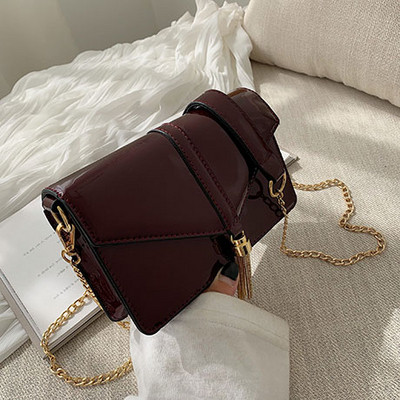 Κομψή γυναικεία τσάντα σε τέσσερα χρώματα με μακρά μεταλλική λαβή και τρισδιάστατα μεταλλικά στοιχεία