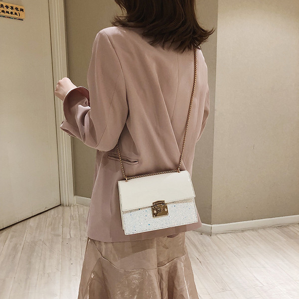 Stílusos női táska fényes elemekkel három színben fém csattal és hosszú fém fogantyúval