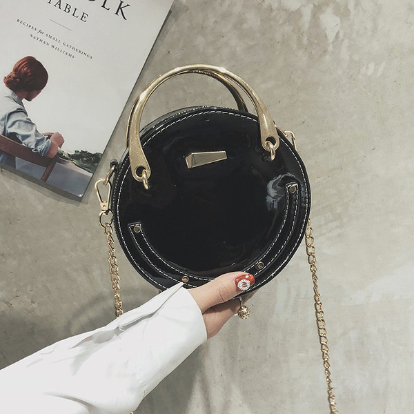 Női lakkbőr táska kerek formával, rövid és hosszú fém fogantyúkkal