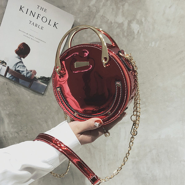 Női lakkbőr táska kerek formával, rövid és hosszú fém fogantyúkkal