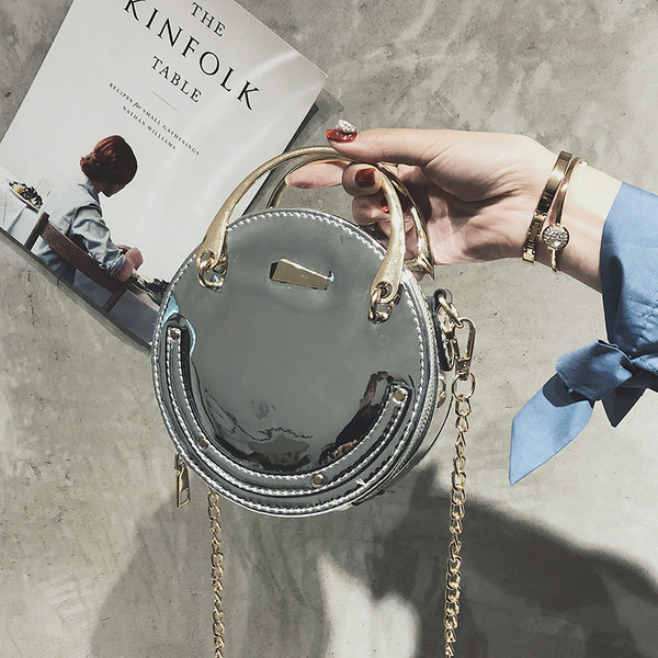 Női lakkbőr táska kerek formával, rövid és hosszú fém fogantyúkkal