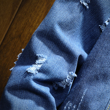 Μοντέρνο ανδρικό μπουφάν σμε μπλε χρώμα, με τσέπες και σχισμένα μοτίβα