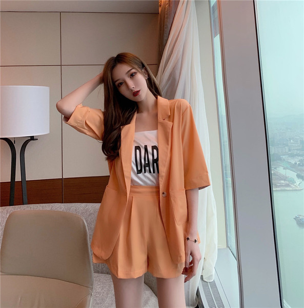 Stílusos női szett fekete és narancssárga kabáttal és rövidnadrággal