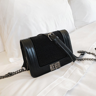 Μοντέρνα γυναικεία τσάντα σε μαύρο χρώμα με λαμπερή διακόσμηση και μεταλλική στερέωση με μεγάλη μεταλλική αλυσίδα