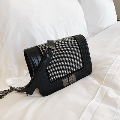 Μοντέρνα γυναικεία τσάντα σε μαύρο χρώμα με λαμπερή διακόσμηση και μεταλλική στερέωση με μεγάλη μεταλλική αλυσίδα