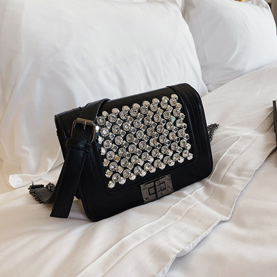 Μοντέρνα γυναικεία τσάντα σε μαύρο χρώμα με λαμπερή διακόσμηση και μεταλλική στερέωση με μεγάλη μεταλλική αλυσίδα