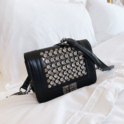 Μοντέρνα γυναικεία τσάντα σε μαύρο χρώμα με λαμπερή διακόσμηση και μεταλλική στερέωση με μεγάλη μεταλλική αλυσίδα