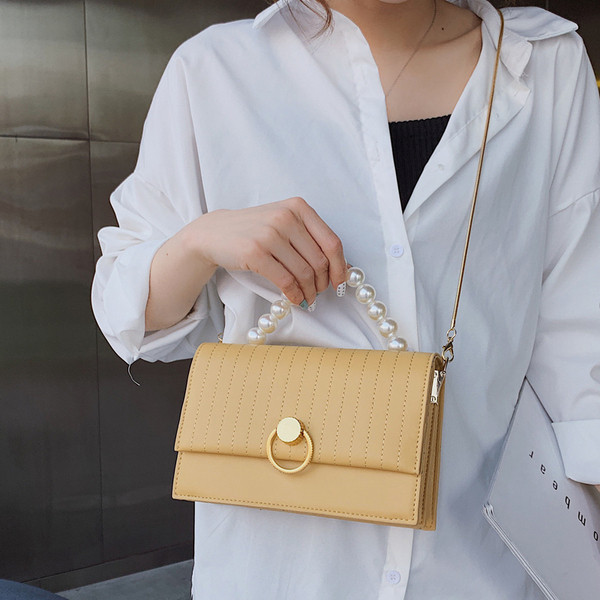 Μοντέρνα γυναικεία έκο δερμάτινη τσάντα σε τέσσερα χρώματα με μικρή λαβή μαργαριταριών και μεταλλική στερέωση