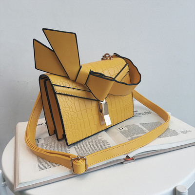 Κομψή γυναικεία τσάντα  σε πέντε χρώματα οικολογικού δέρμα με μεταλλικό κούμπομα και κορδέλα