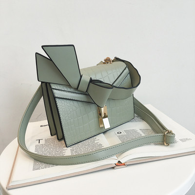 Κομψή γυναικεία τσάντα  σε πέντε χρώματα οικολογικού δέρμα με μεταλλικό κούμπομα και κορδέλα