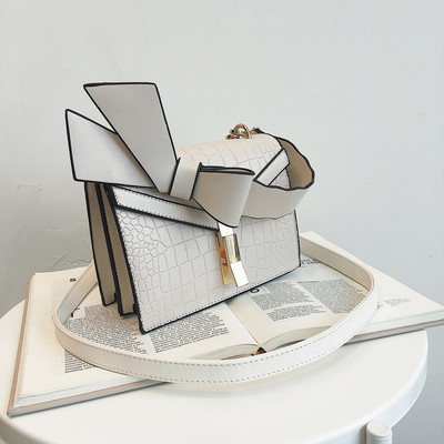 Κομψή γυναικεία τσάντα  σε πέντε χρώματα οικολογικού δέρμα με μεταλλικό κούμπομα και κορδέλα