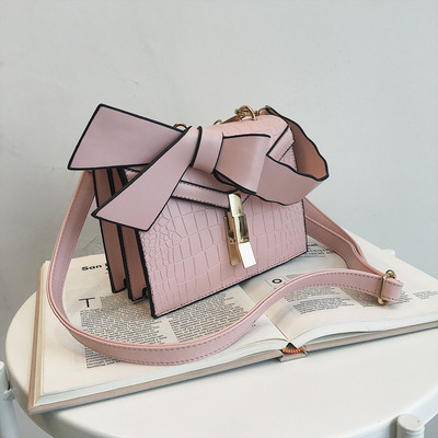 Κομψή γυναικεία τσάντα  σε πέντε χρώματα οικολογικού δέρμα με μεταλλικό κούμπομα και κορδέλα