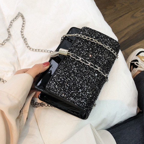 Stílusos kézitáska három színben fényes elemekkel és fémlánccal