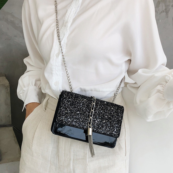 Stílusos kézitáska három színben fényes elemekkel és fémlánccal