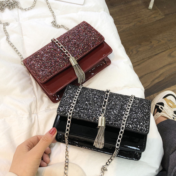 Stílusos kézitáska három színben fényes elemekkel és fémlánccal