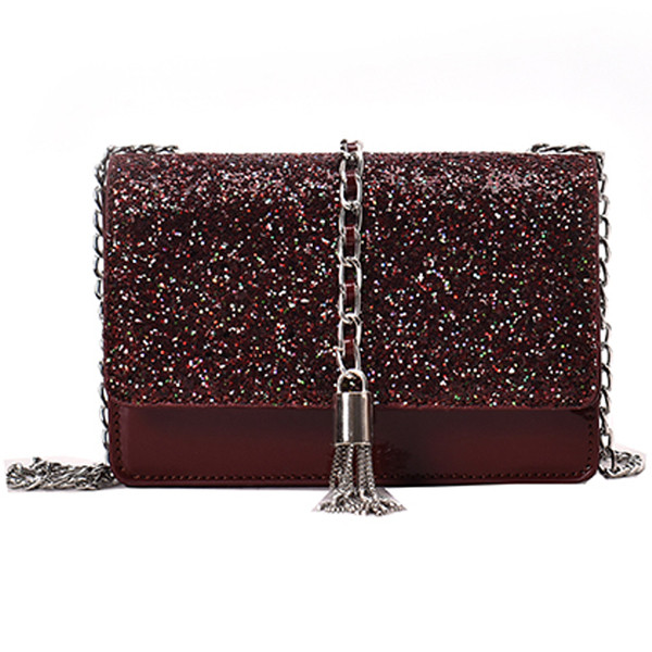 Stílusos kézitáska három színben fényes elemekkel és fémlánccal