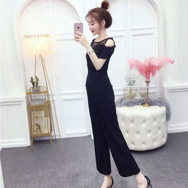 Modern női jumpsuit fekete és piros színben, vágott váll és rövid ujjú