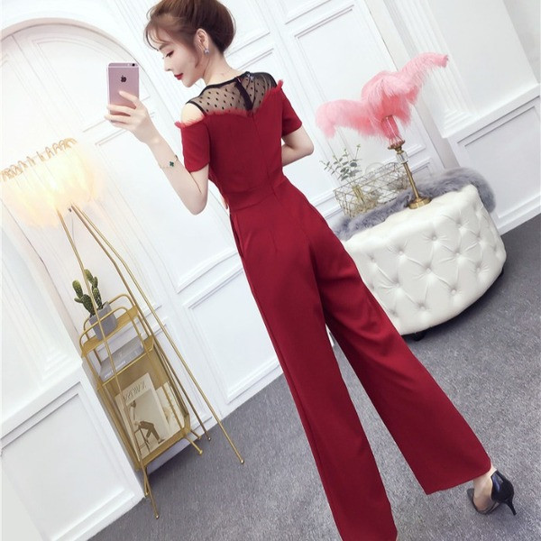 Modern női jumpsuit fekete és piros színben, vágott váll és rövid ujjú