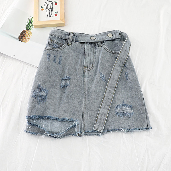 Modern női farmerszoknya szakadt elemekkel